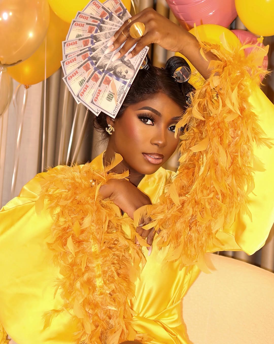 Client in a yellow feathered robe at a birthday shoot with full glam